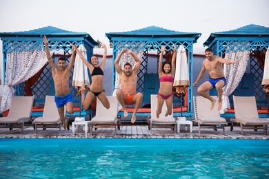 Photo of Happy young friends jumping in swimming pool