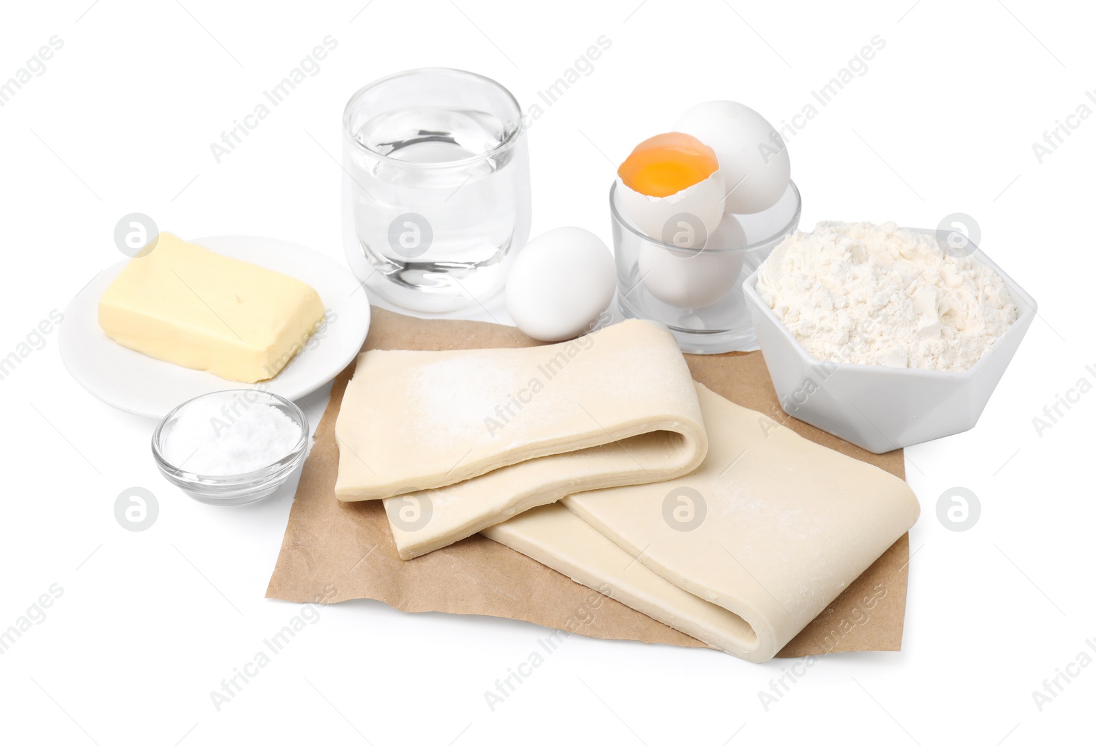 Photo of Raw puff pastry dough and ingredients isolated on white