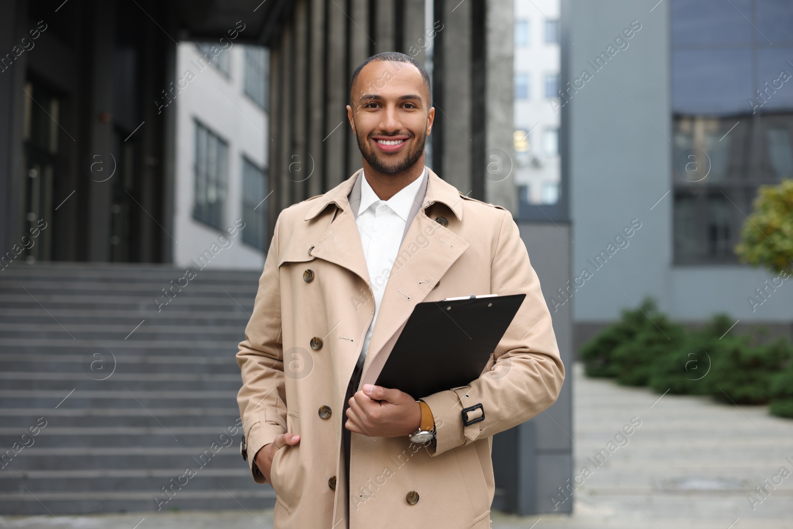 Photo of Happy man with clipboard outdoors. Lawyer, businessman, accountant or manager