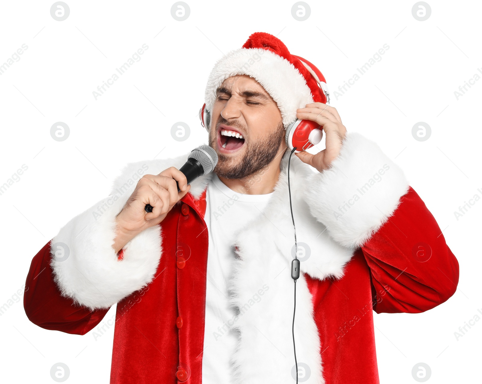 Photo of Young man in Santa costume singing into microphone on white background. Christmas music