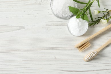 Photo of Flat lay composition with toothbrushes and herbs on white wooden table. Space for text