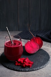 Slate plate with glass of beet smoothie on table