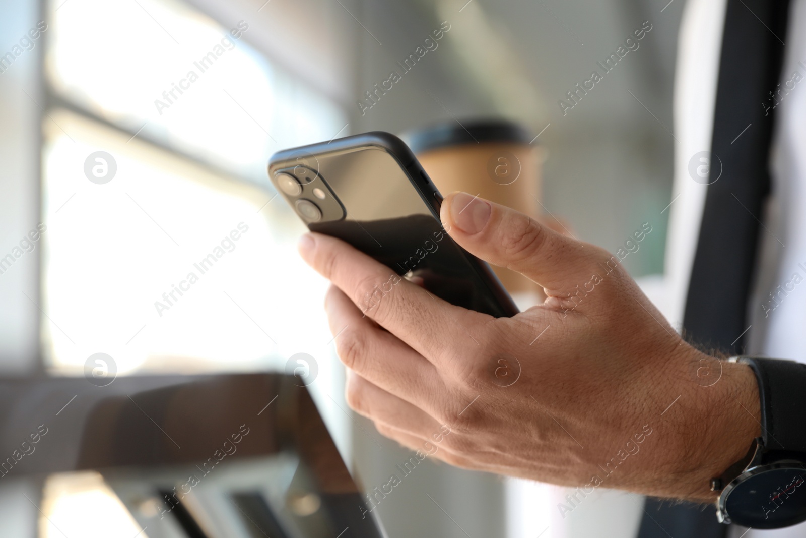 Photo of MYKOLAIV, UKRAINE - MARCH 16, 2020: Man holding iPhone 11 Black indoors, closeup