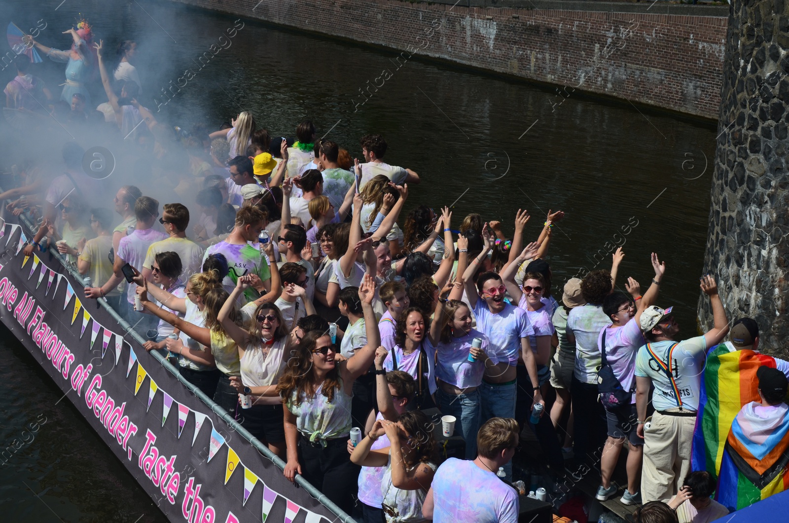 Photo of AMSTERDAM, NETHERLANDS - AUGUST 06, 2022: Many people in boat at LGBT pride parade on river