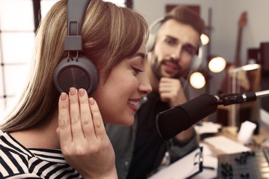 Man interviewing young woman in modern radio studio