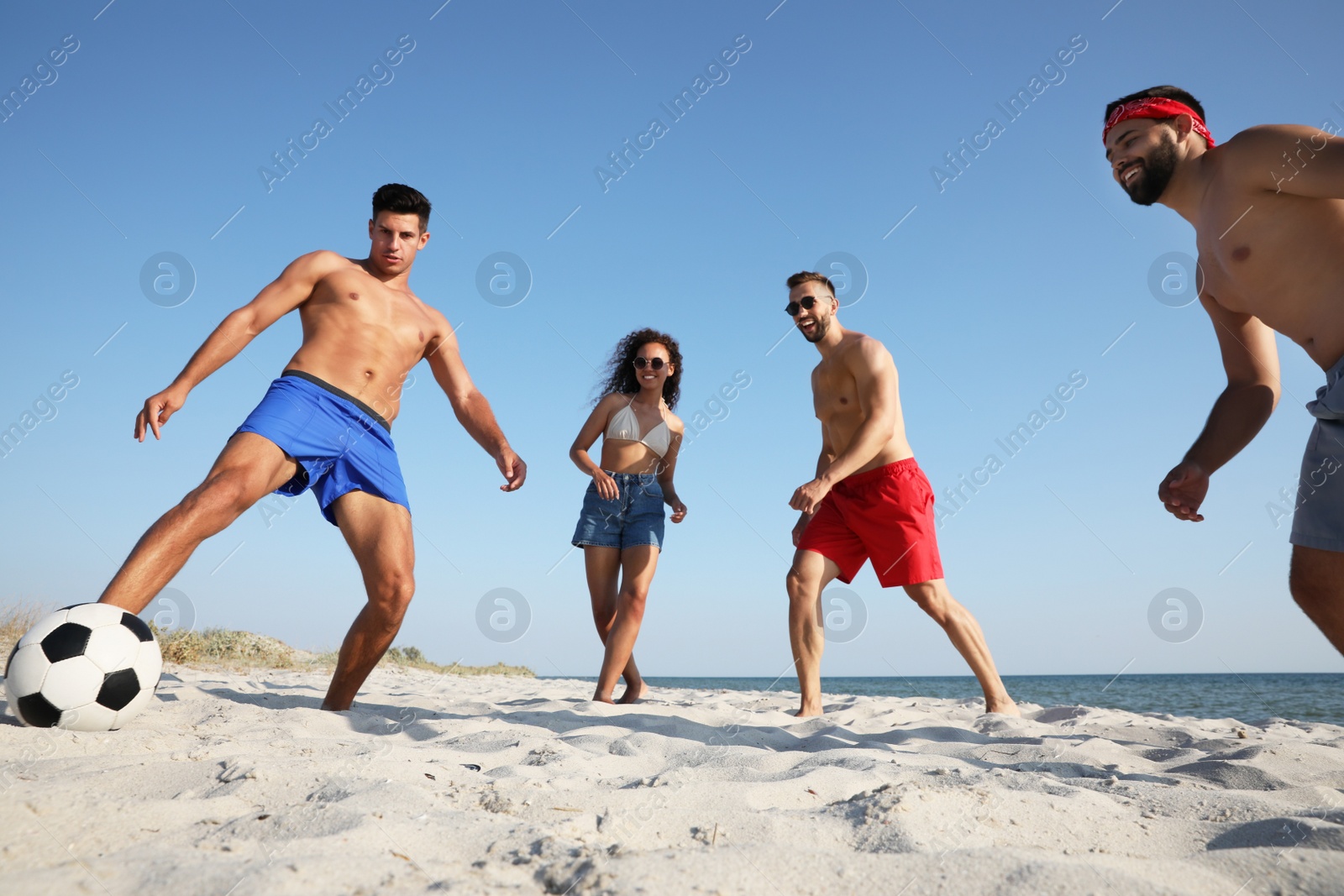 Photo of Group of friends playing football on beach