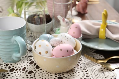 Photo of Festive table setting with painted eggs, closeup. Easter celebration