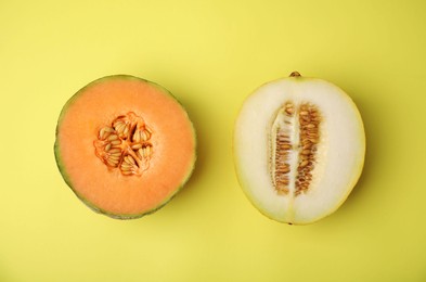 Tasty colorful ripe melons on yellow background, flat lay