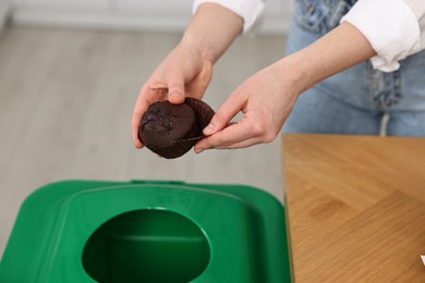 Garbage sorting. Woman throwing muffin liner into trash bin indoors, closeup
