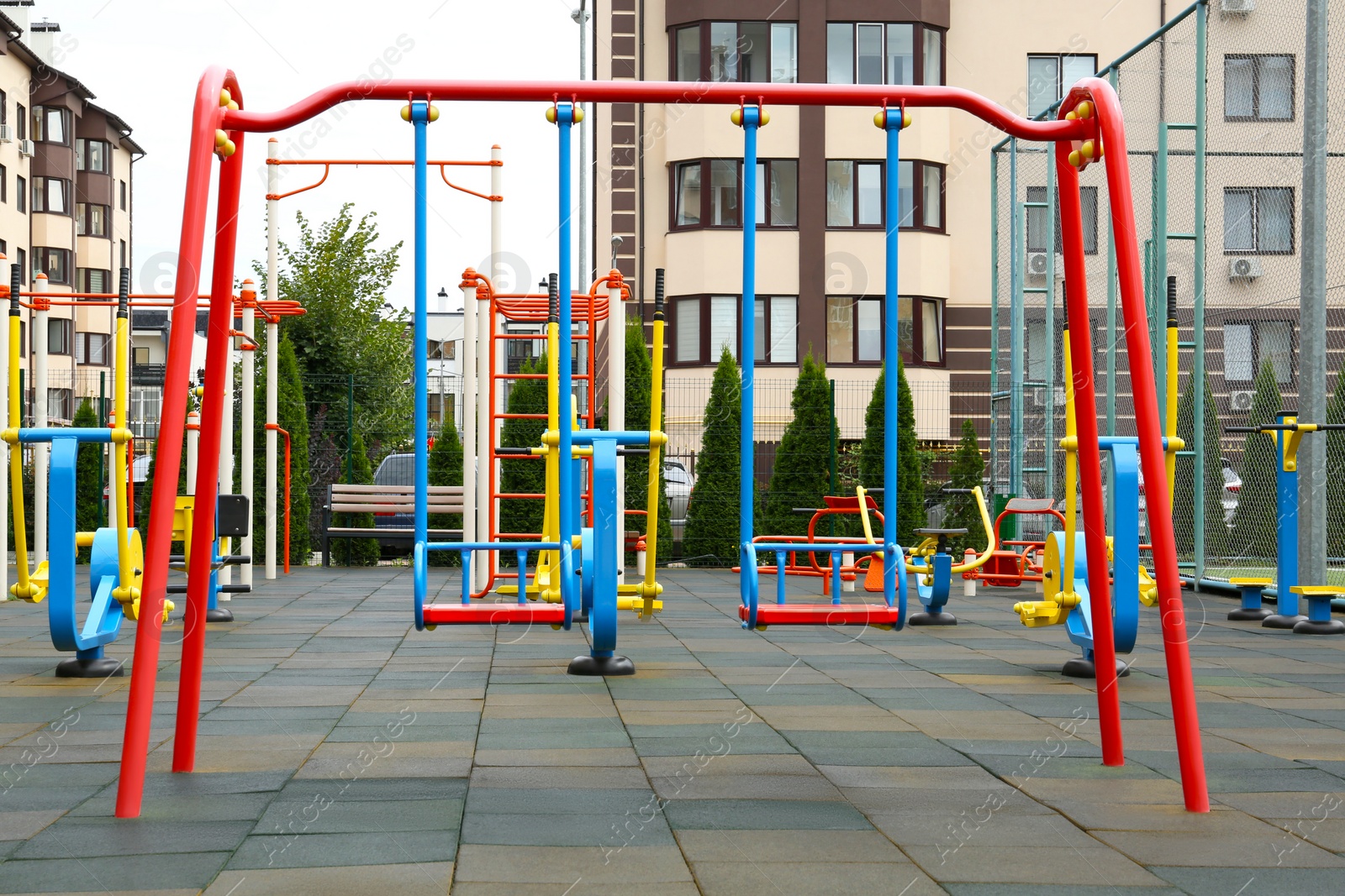 Photo of Empty outdoor children's playground with swings in residential area