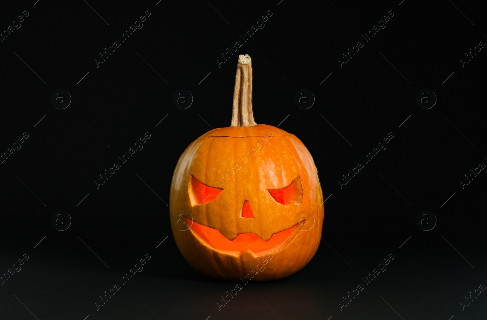 Photo of Pumpkin head on black background. Jack lantern - traditional Halloween decor