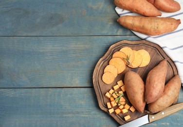 Photo of Sweet potatoes and knife on light blue wooden table, flat lay. Space for text