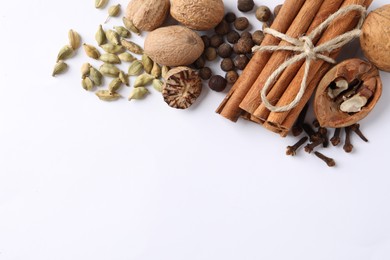 Photo of Different spices and nuts on white table, flat lay. Space for text