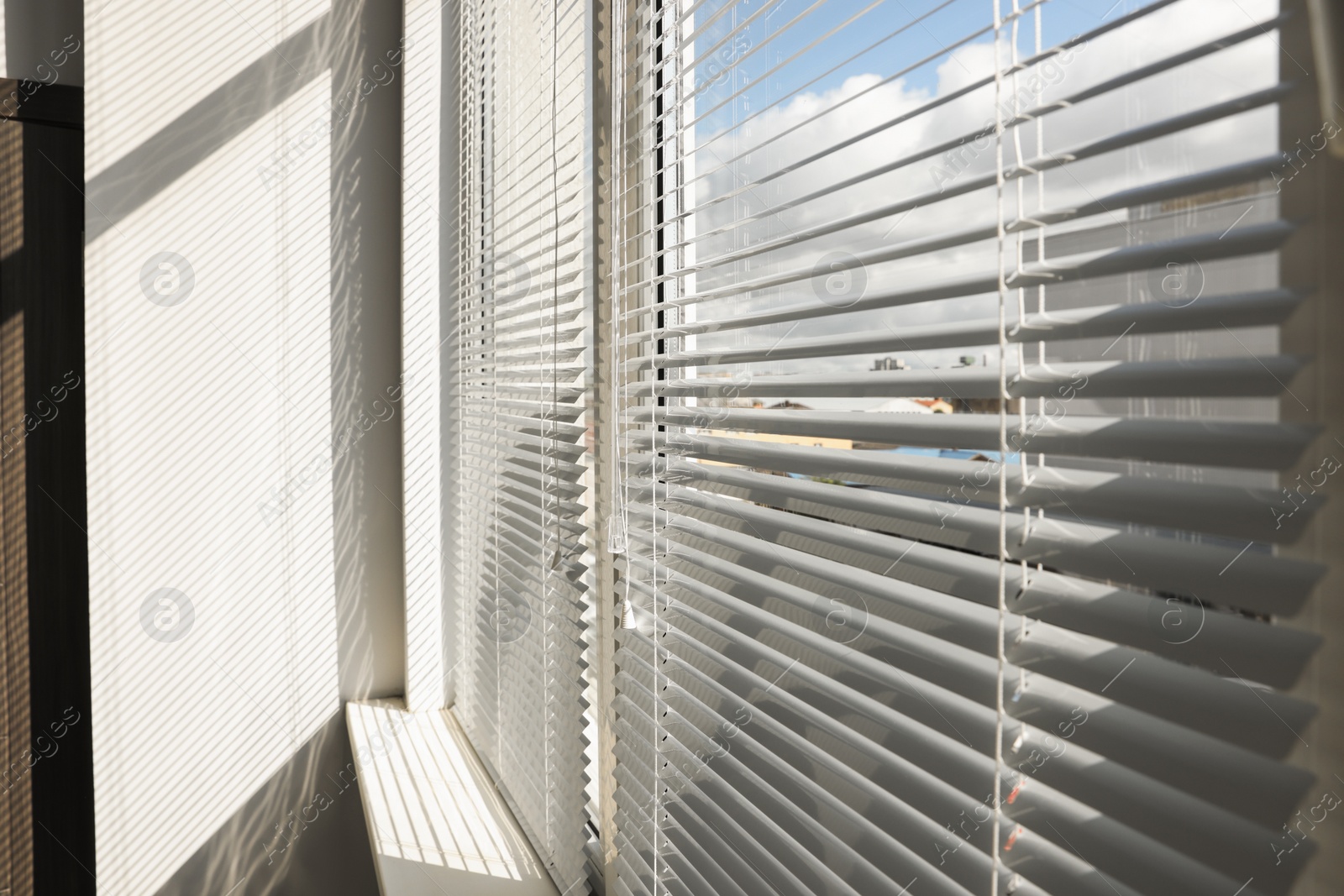 Photo of Stylish window with horizontal blinds in room