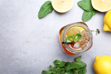 Photo of Delicious iced tea with lemon and mint on grey table, flat lay. Space for text