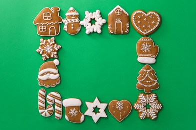 Photo of Frame made with different Christmas gingerbread cookies on green background, top view. Space for text