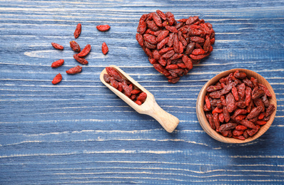 Photo of Flat lay composition with dry goji berries on blue wooden table