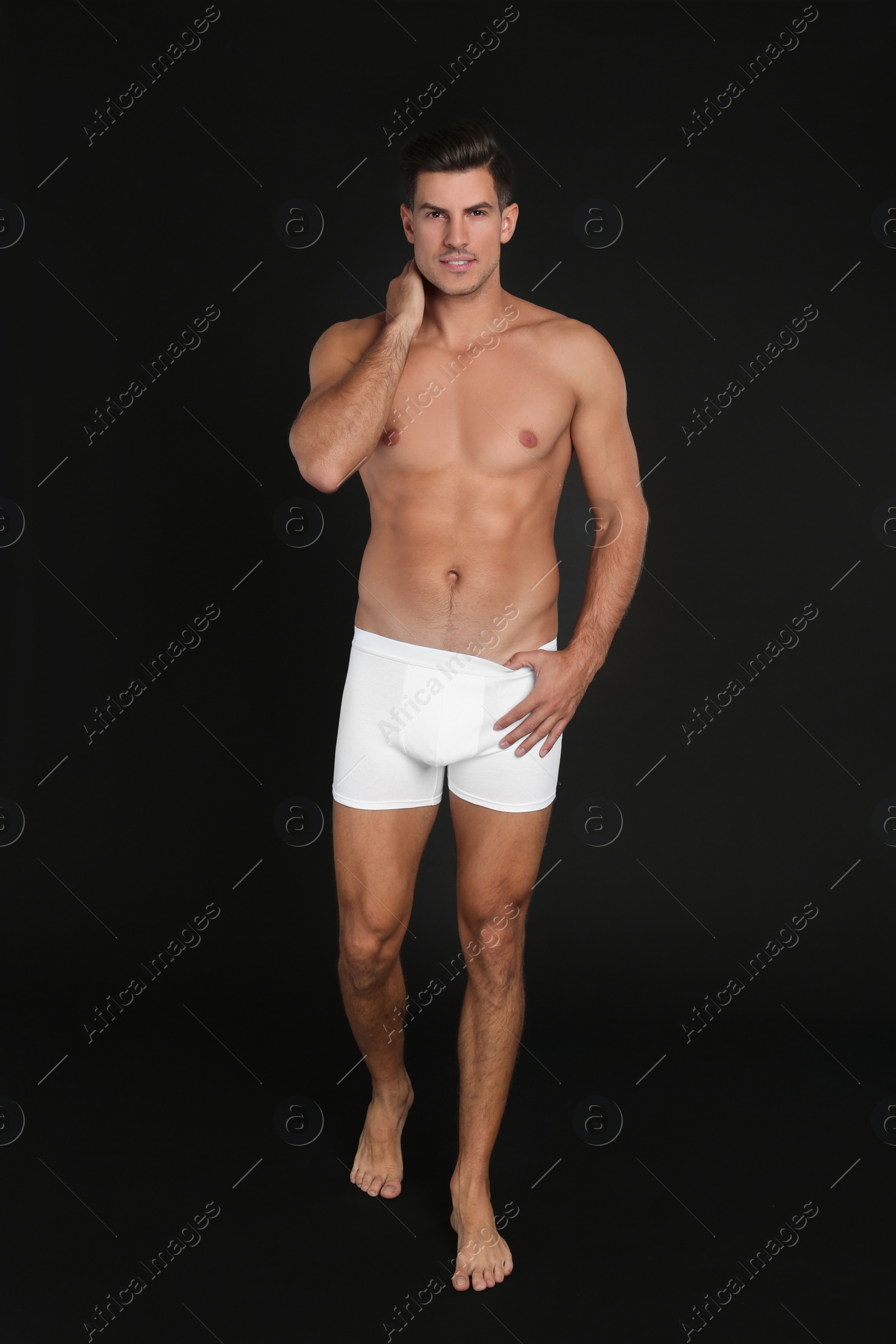 Photo of Handsome man in underwear on black background