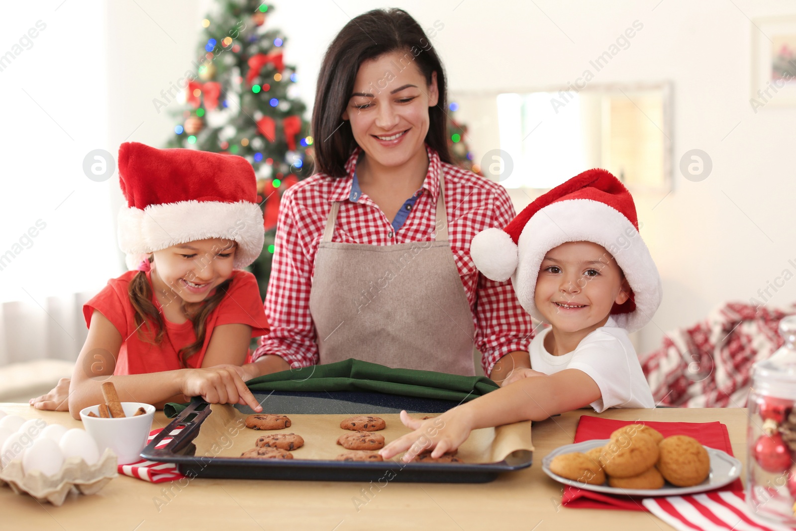 Photo of Mother and children making Christmas cookies together at home