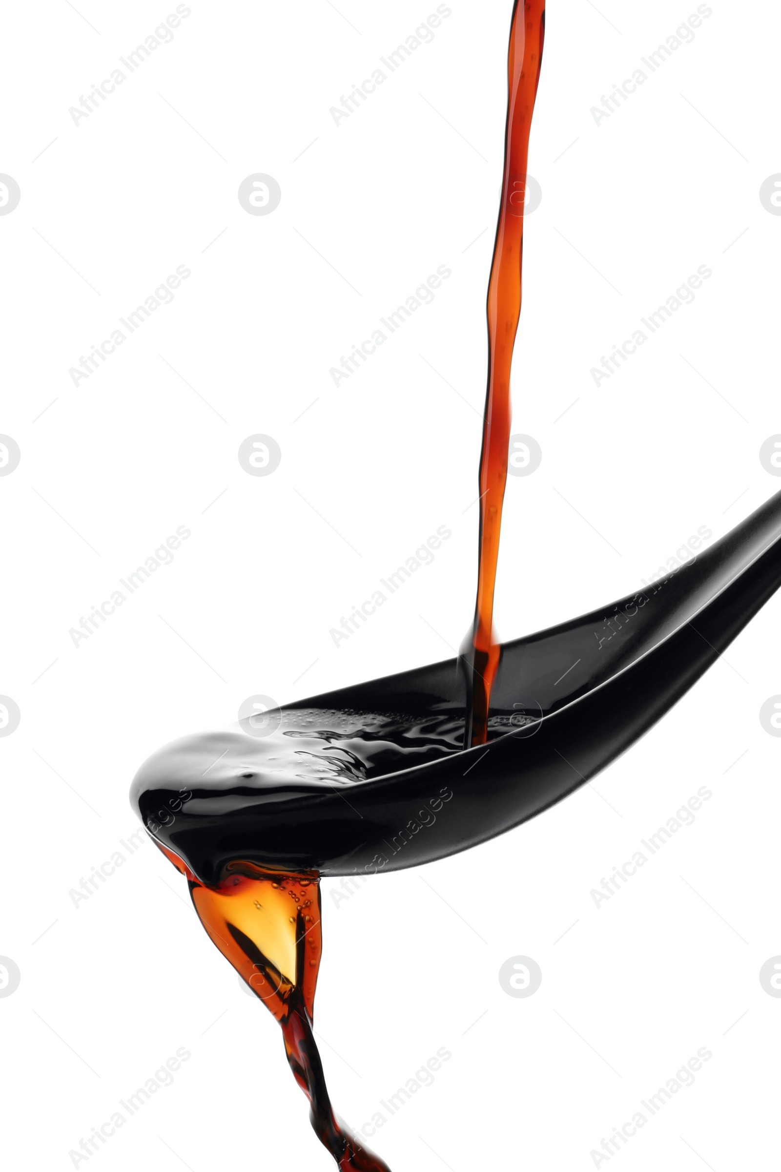 Photo of Pouring soy sauce into spoon against white background