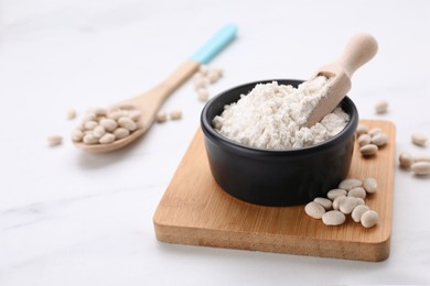 Bean flour and seeds on white marble table. Space for text