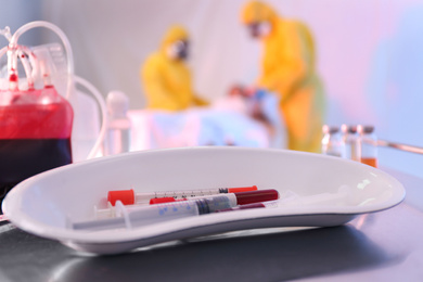 Photo of Medical bowl with samples of virus on table in quarantine ward, closeup