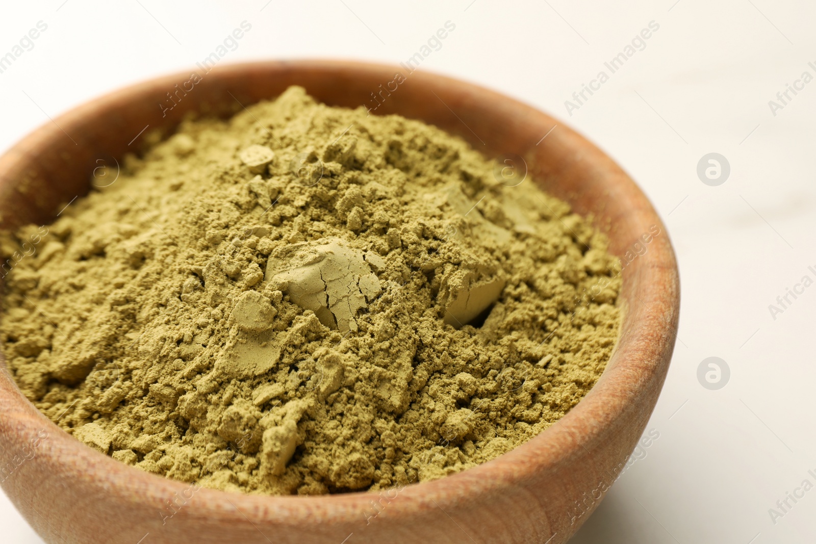 Photo of Bowl of henna powder on white marble table, closeup