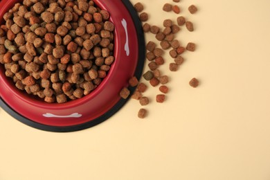 Photo of Dry dog food and feeding bowl on beige background, flat lay. Space for text