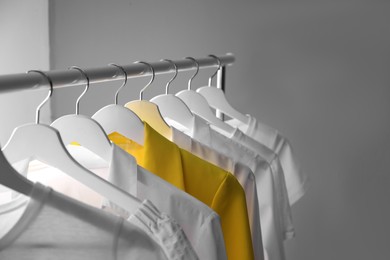 Yellow jacket hanging on rack among other clothes. Diversity concept