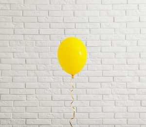 Photo of Bright balloon near brick wall. Celebration time