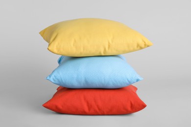 Stack of stylish soft pillows on grey background