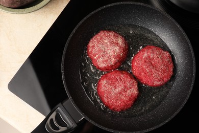 Photo of Frying vegan cutlets on cooktop, top view