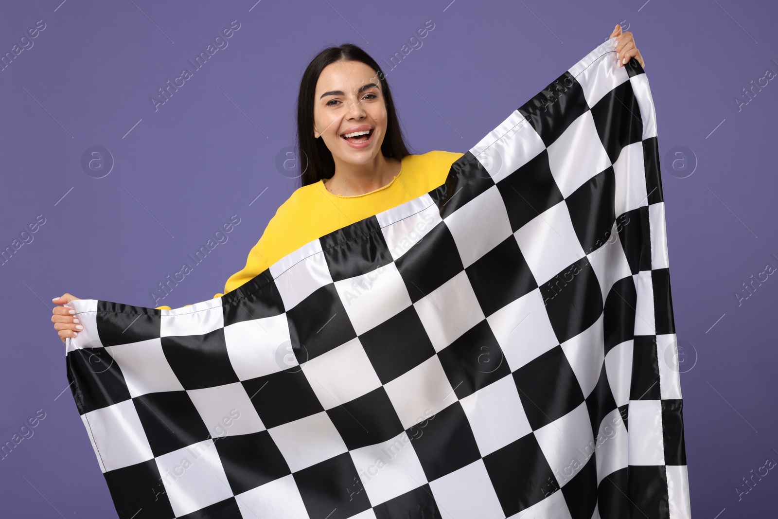 Photo of Happy young woman with checkered flag on violet background