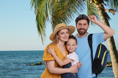 Image of Portrait of happy family with child near palm on beach