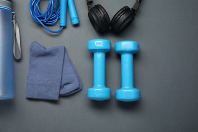 Sports equipment, socks and headphones on grey background, flat lay