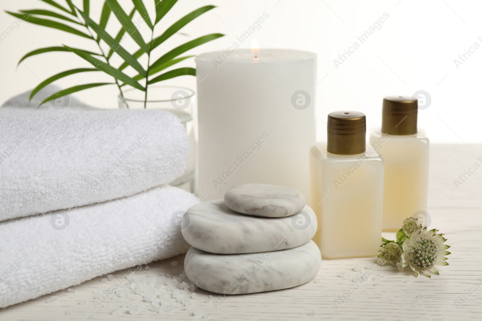Photo of Composition with spa stones on white wooden table