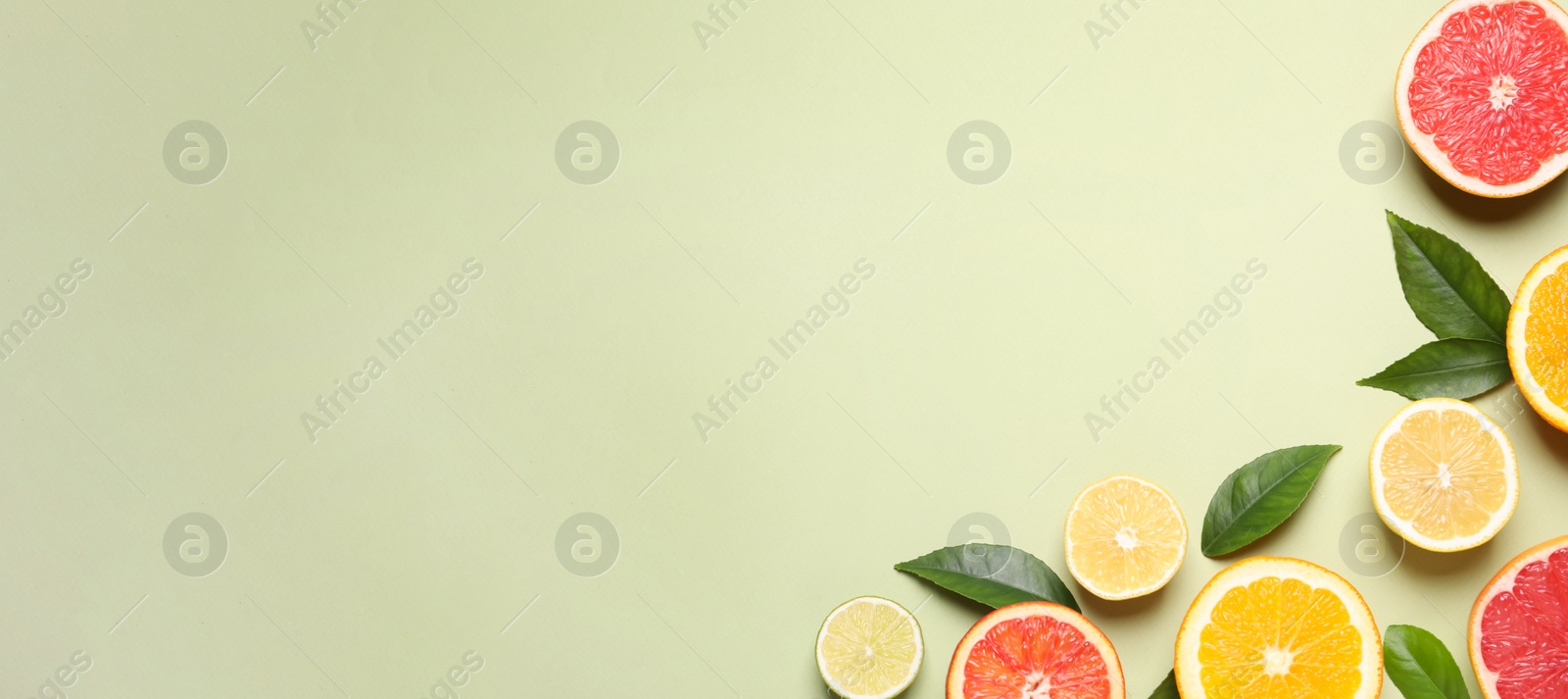 Photo of Fresh juicy citrus fruits with green leaves on light background, flat lay. Space for text