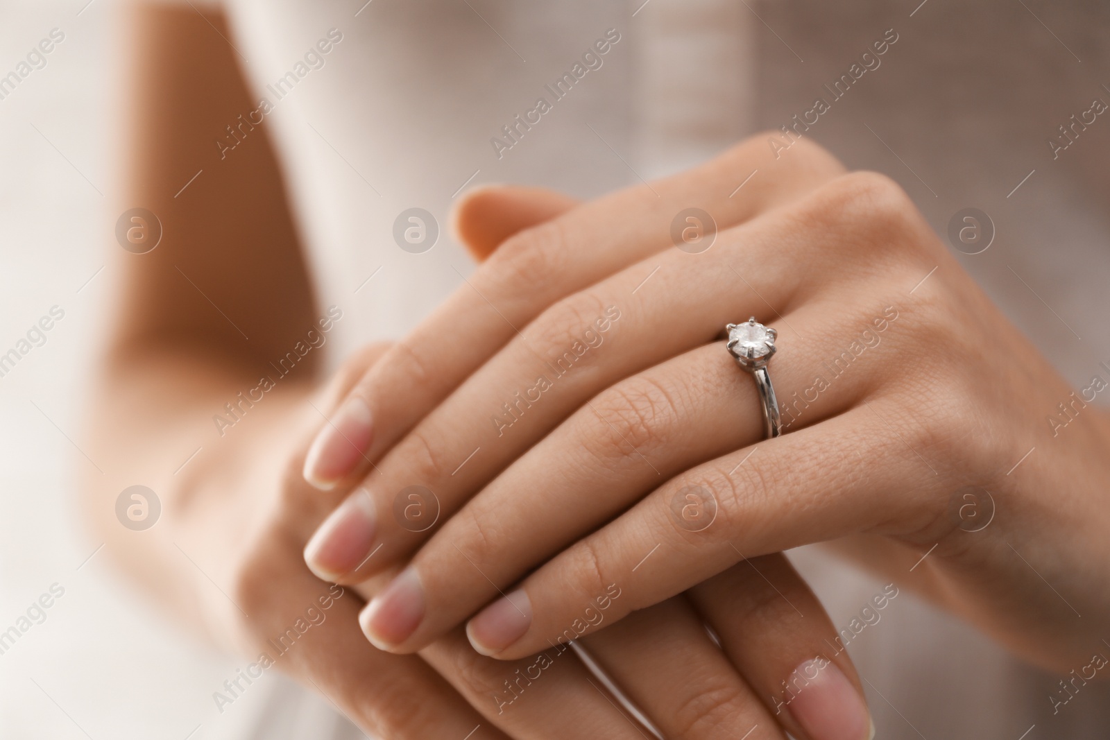 Photo of Young bride wearing beautiful engagement ring, closeup