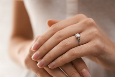 Photo of Young bride wearing beautiful engagement ring, closeup