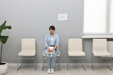 Woman sitting on chair and waiting for job interview indoors