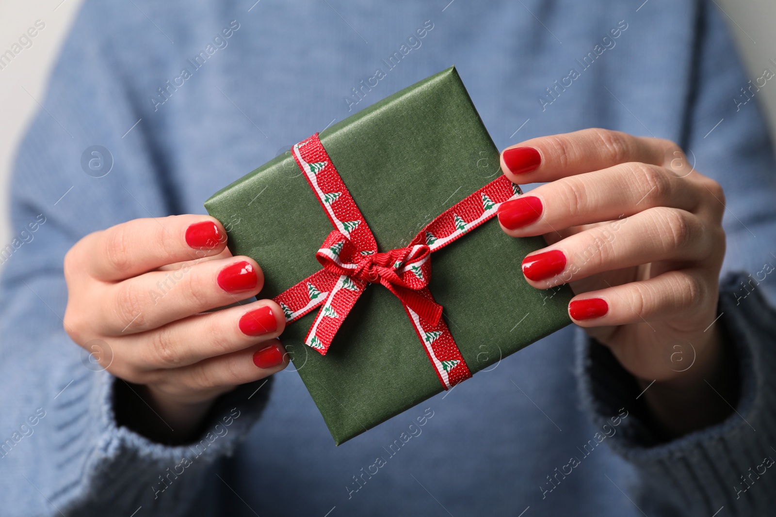 Photo of Christmas present. Woman holding gift box, closeup