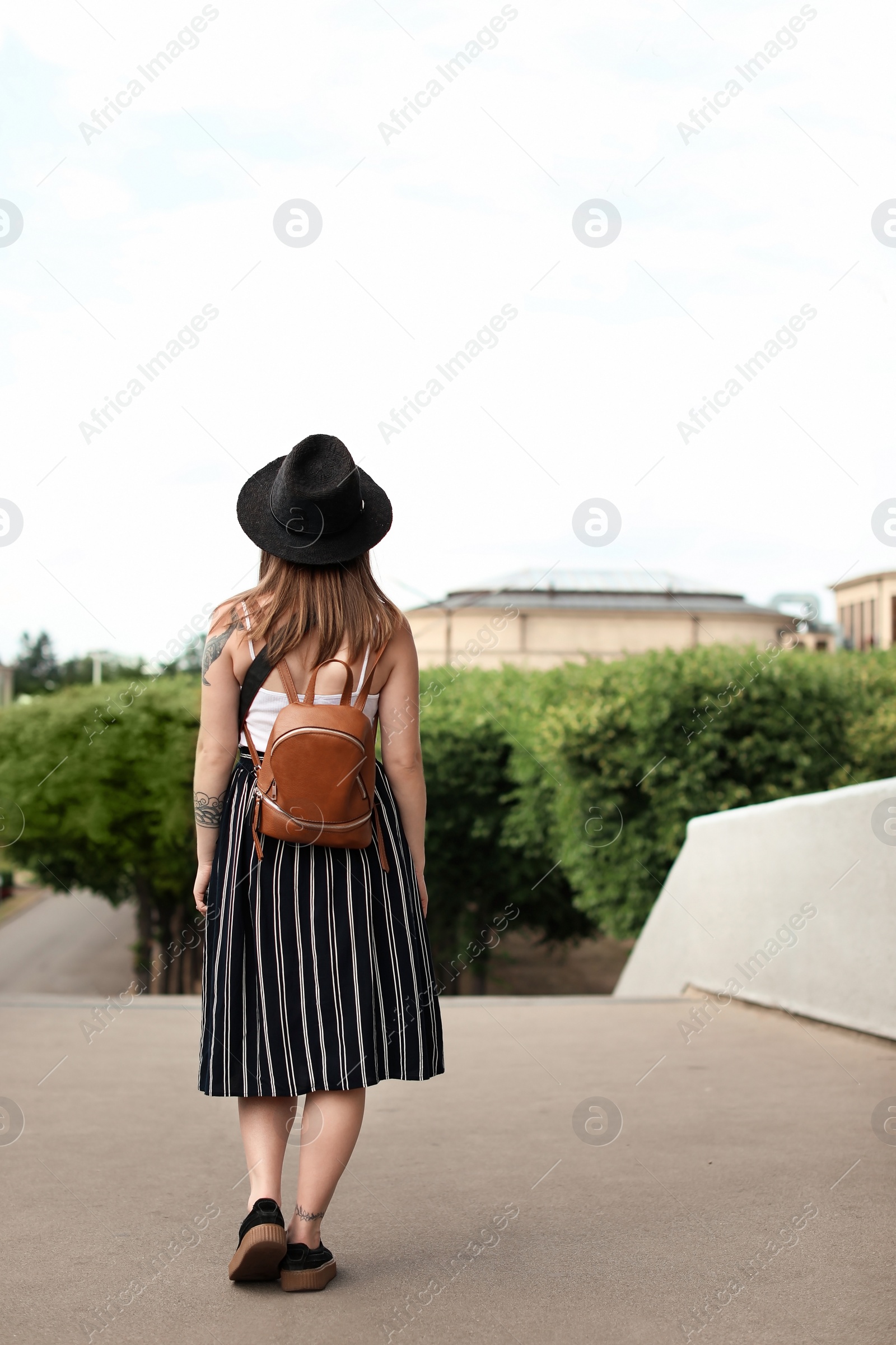 Photo of Young woman in stylish outfit on city street