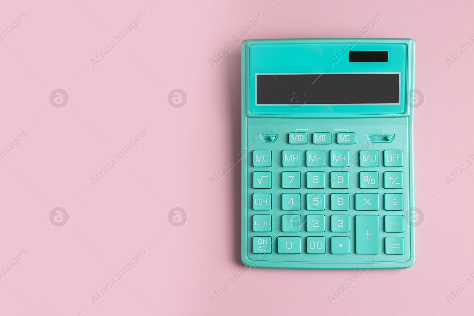 Photo of Turquoise calculator on pink background, top view. Space for text