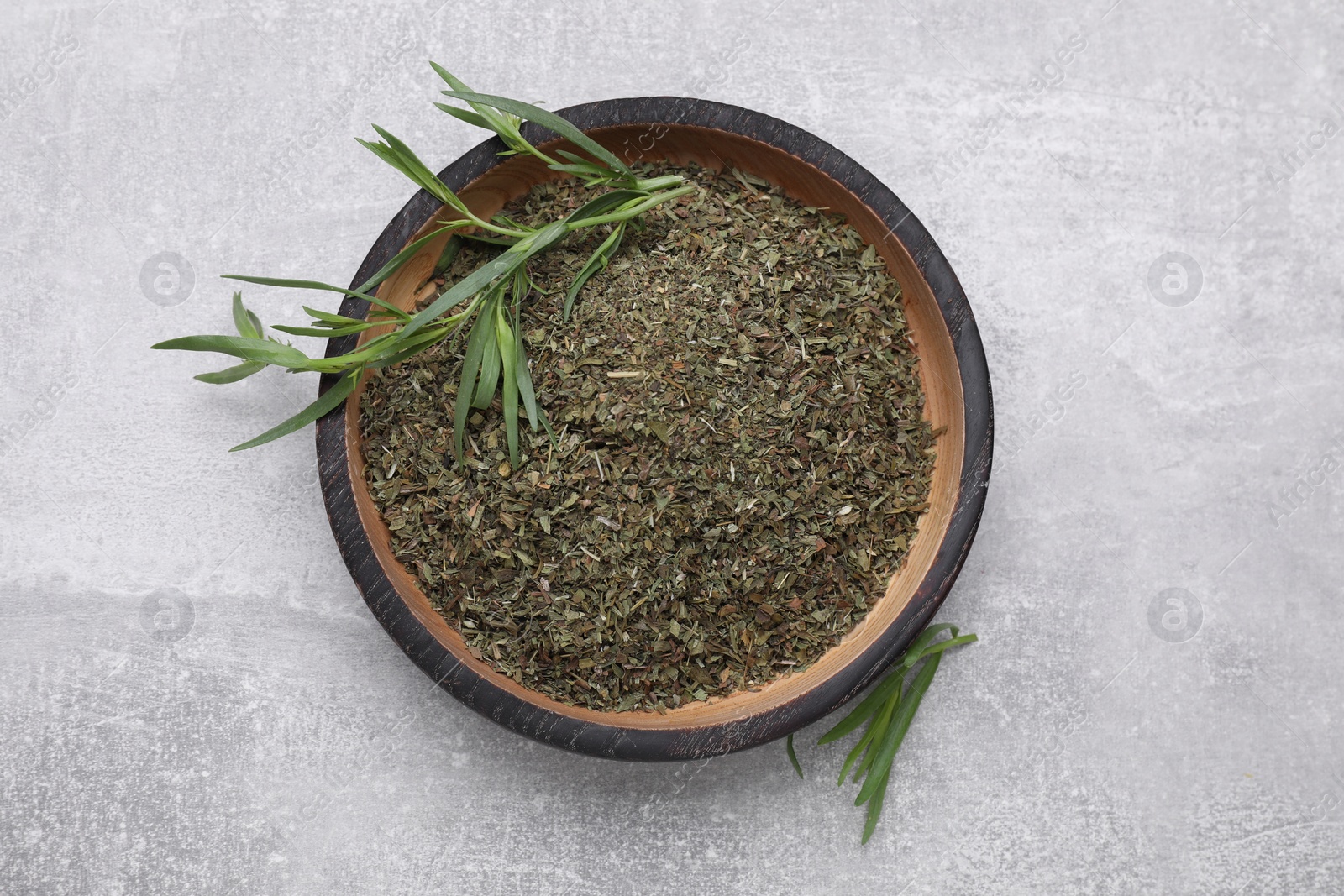 Photo of Dry and fresh tarragon on light gray textured table, top view