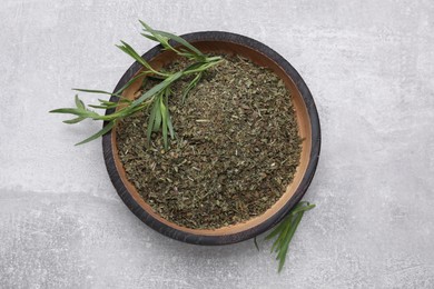 Dry and fresh tarragon on light gray textured table, top view