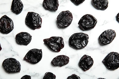 Flat lay of dried plums on marble background. Healthy fruit