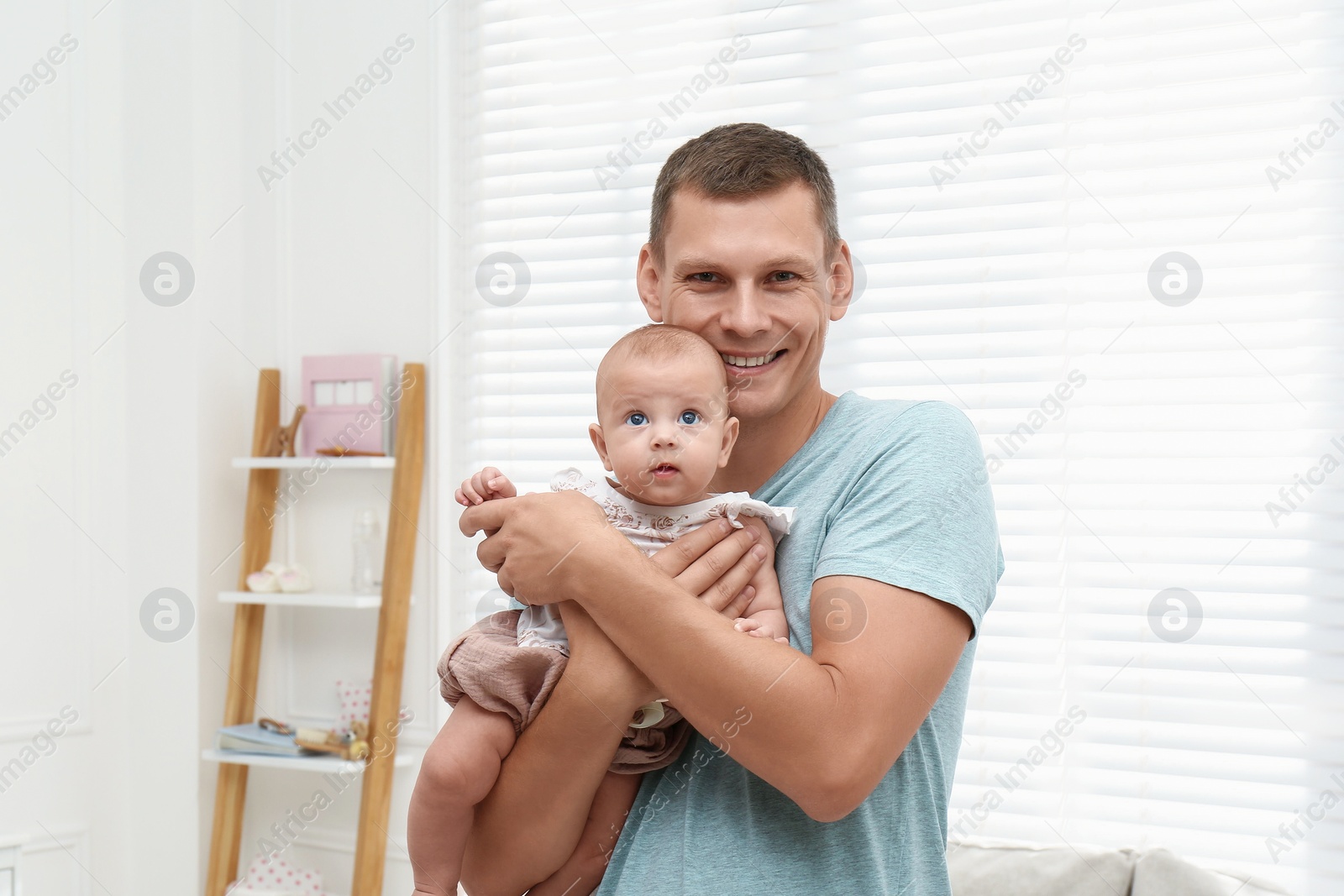 Photo of Happy father with his little baby at home