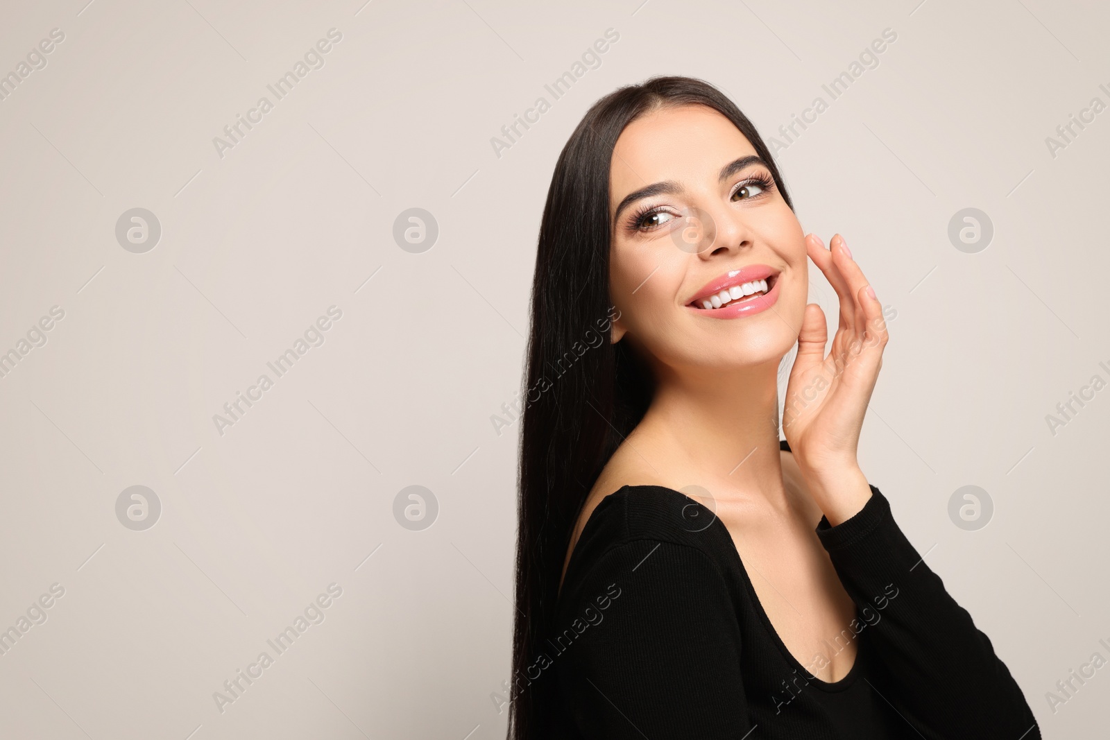 Photo of Portrait of beautiful young woman on light grey background. Space for text