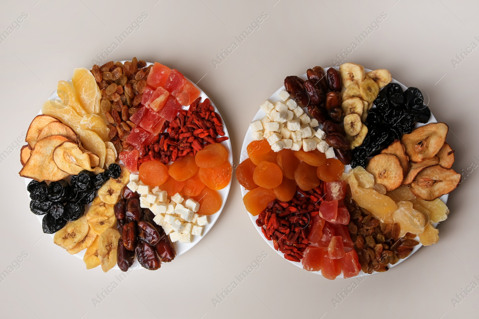 Photo of Plates with different dried fruits on white background, top view