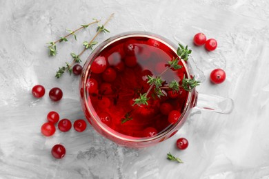 Photo of Delicious cranberry tea with thyme and berries on grey table, flat lay